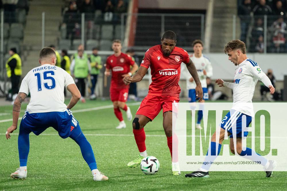 THUN, BERN - OCTOBER 22: Brighton Labeau of FC Thun holds off Dario Mareöi? and äimun Hrgovi? of HNK Hajduk Split to retain possession of the ball during the UEFA Conference League match between FC Thun and HNK Hajduk Split at VISANA STADION on October 22, 2026 in Thun, Bern, Switzerland.