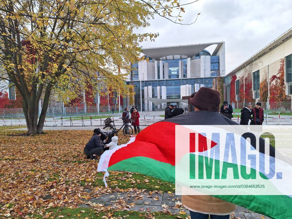 Berlin, Deutschland, 15.11.2023: Pro-Palästinenser-Protest vor dem Kanzleramt; mehrere Personen hatten sich mit Palästinenser-Fahnen versammelt, hier eine Frau mit Flagge, Polizei war vor Ort (Foto von 15:20 Uhr)