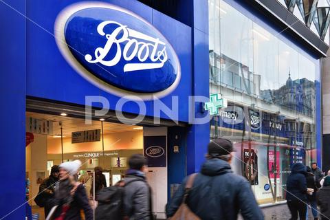 Typical blue oval sign at one of many Boots branches in London. Boots is a health and beauty pharmacy chain in UK and few other countries boots london store entrance white blue beauty branch brand british building business chain chemist city commerce commercial company corporation drug drugstore emblem england facade front health high kingdom logo medical medication medicine name pharmaceutical pharmacist pharmacy prescription retail shop sign signage street symbol trademark uk united