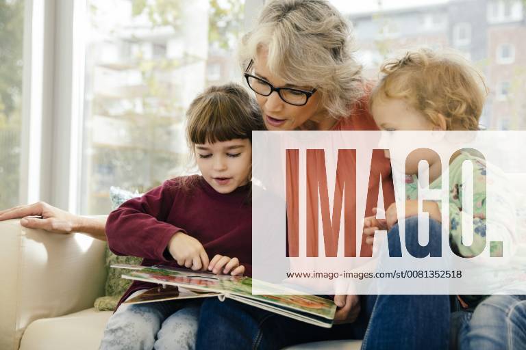 Pre-school teacher reading with children in kindergarten model released Symbolfoto property released MFF04065