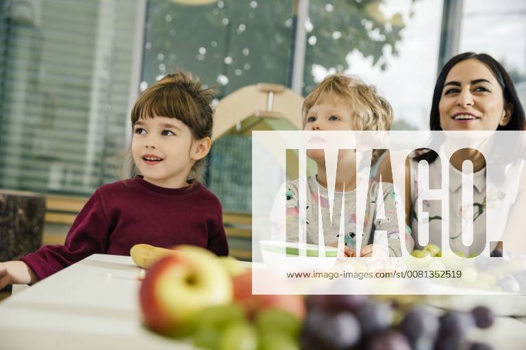 Children and teacher sitting at table with fruit in kindergarten model released Symbolfoto property released MFF04072