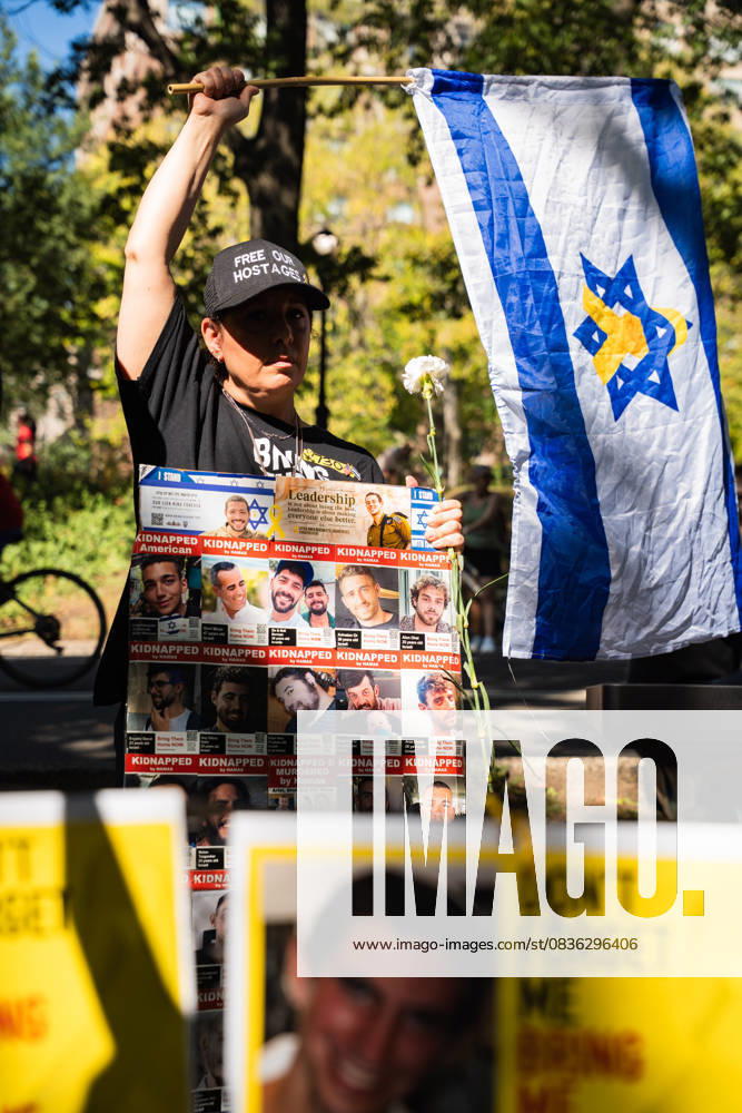 A demonstrator holds an Israeli flag and a sign as hundreds rally in Central Park in support of a deal to end the war in Gaza and free the remaining Israeli hostages in a rally that marks two years since the war began. The negotiating teams are set to start finalizing the details of a ceasefire on Monday according to US President Donald TrumpÃ¢â‚¬â ¢s peace plan. New York USA - ZUMAg280 20251005_znp_g280_020