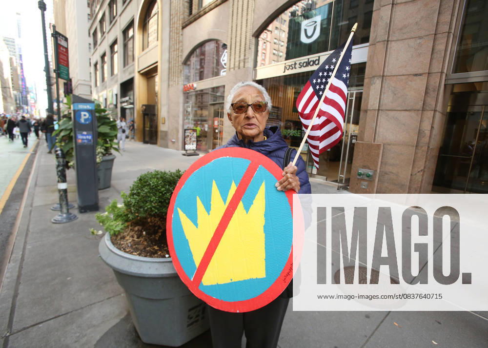 A woman holds a sign and an American Flag during the No Kings protest in New York City on Oct. 18, 2025. Tens of thousands of people hit New York City streets to protest Donald Trump, autocracy, ICE and immigrant deportations. More than 2,500 similar protests took place nationwide. New York City USA - ZUMAk45_ 20251018_zaf_k45_041