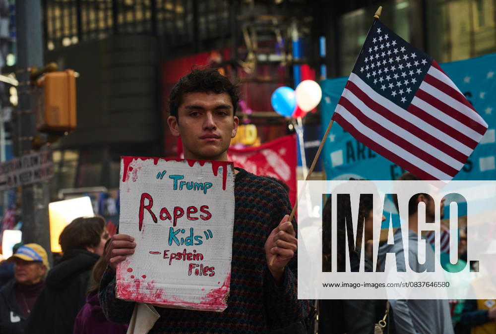 A protester holds an American flag and a sign that reads, â€oeTrump Rapes Kids - Epstein Files†at the New York City No Kings protest. New York USA - ZUMAl171 20251018_znp_l171_039