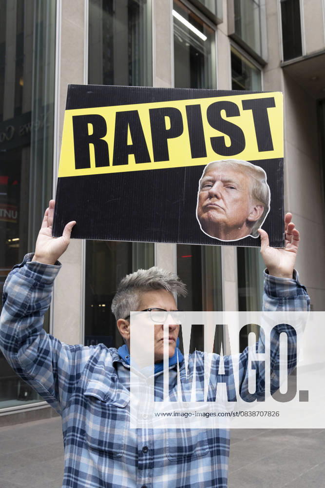 A demonstrator holds a sign that reads RAPIST with an image of President Trump, joining peaceful protesters outside of News Corp s Fox News Channel in midtown Manhattan. People with the activist groups Rise & Resist and Truth Tuesdays call for truth in journalism and denounce ICE, Federal troops sent to cities and Fox News as extremist right-wing propaganda in support of President Trump s administration. New York USA - ZUMAr174 20251028_znp_r174_026