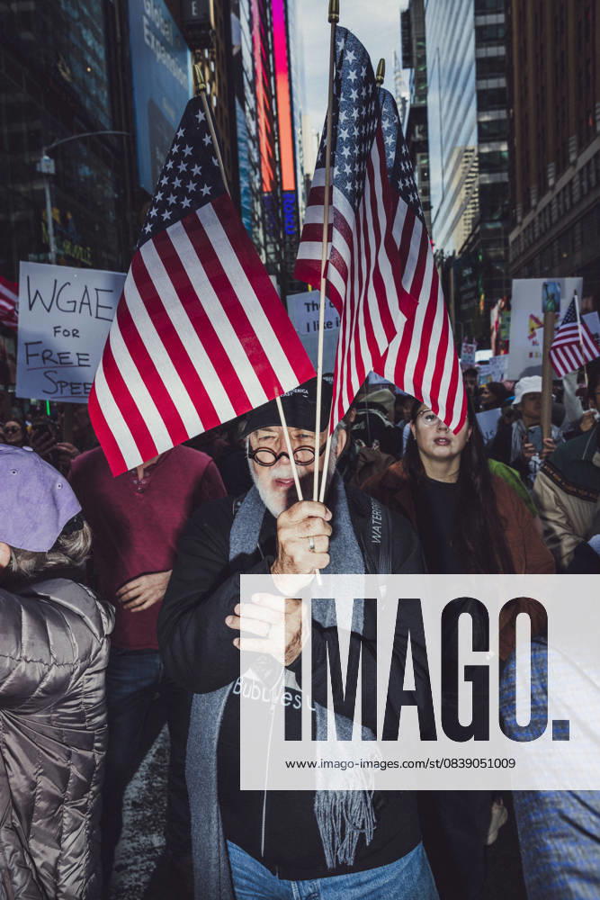 A demonstrator holds American flags while marching down Manhattan during the second No Kings protest. An estimated 350,000 came to this event. New York USA - ZUMAp287 20251018_znp_p287_007