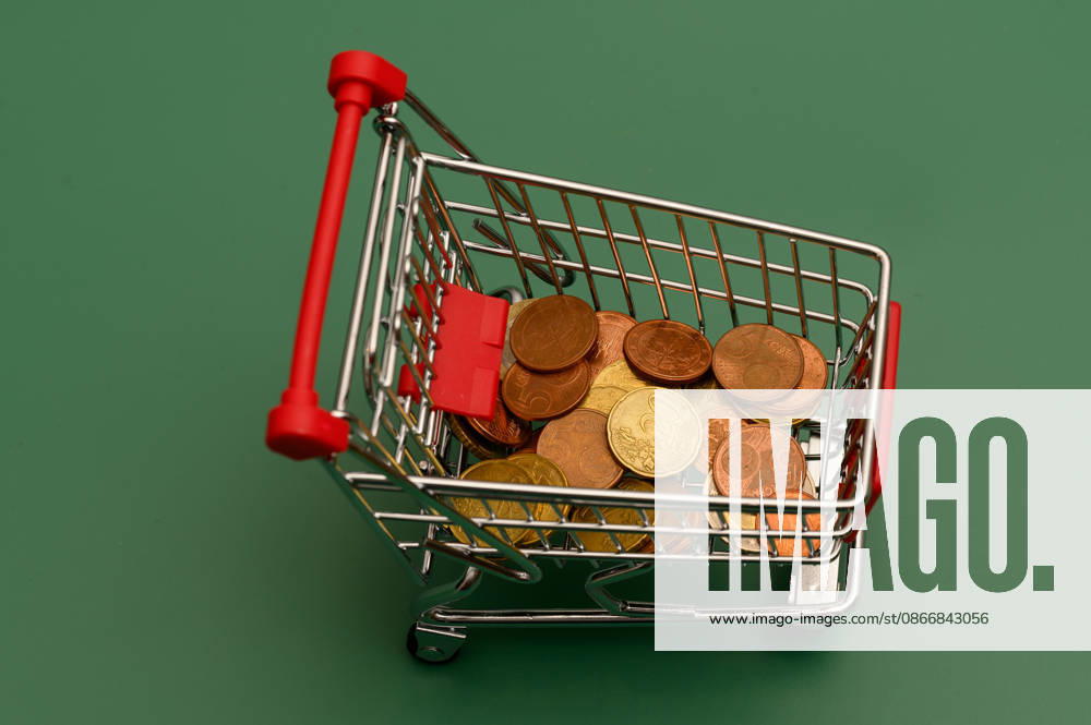 Mini-Einkaufswagen mit Münzen von oben , Waldsee, Deutschland 14.09.2026: Draufsicht auf einen Mini-Einkaufswagen mit Euromünzen auf grünem Hintergrund. Symbolbild für Kleingeld, Sparen und Haushaltsbudget.