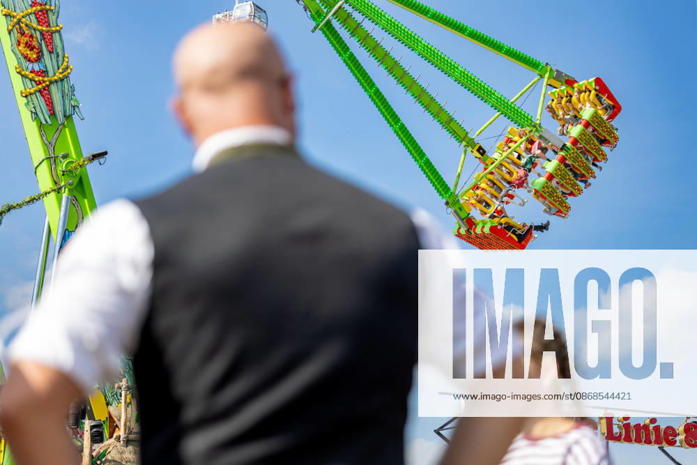 Oktoberfest 2026 in München 04.10.2026: Ein Mann in Tracht blickt auf ein Fahrgeschäft auf dem Oktoberfest. Das 191. Oktoberfest fand 2026 vom 19. September bis 4. Oktober auf der Theresienwiese statt. Das Münchner Oktoberfest zählt zu den größten Volksfesten der Welt und zieht jährlich Millionen Besucher aus Deutschland und dem Ausland an. Muenchen Theresienwiese Bayern Deutschland