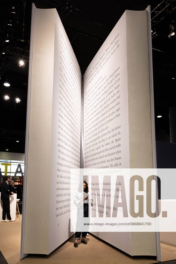 78. Frankfurter Buchmesse Eine Besucherin der Frankfurter Buchmesse ließt ein Buch in einem riesigen Buch-Modell. Die 78. Frankfurter Buchmesse findet vom 7. - 11. Oktober 2026 statt. Frankfurt am Main Messegelände Hessen Deutschland