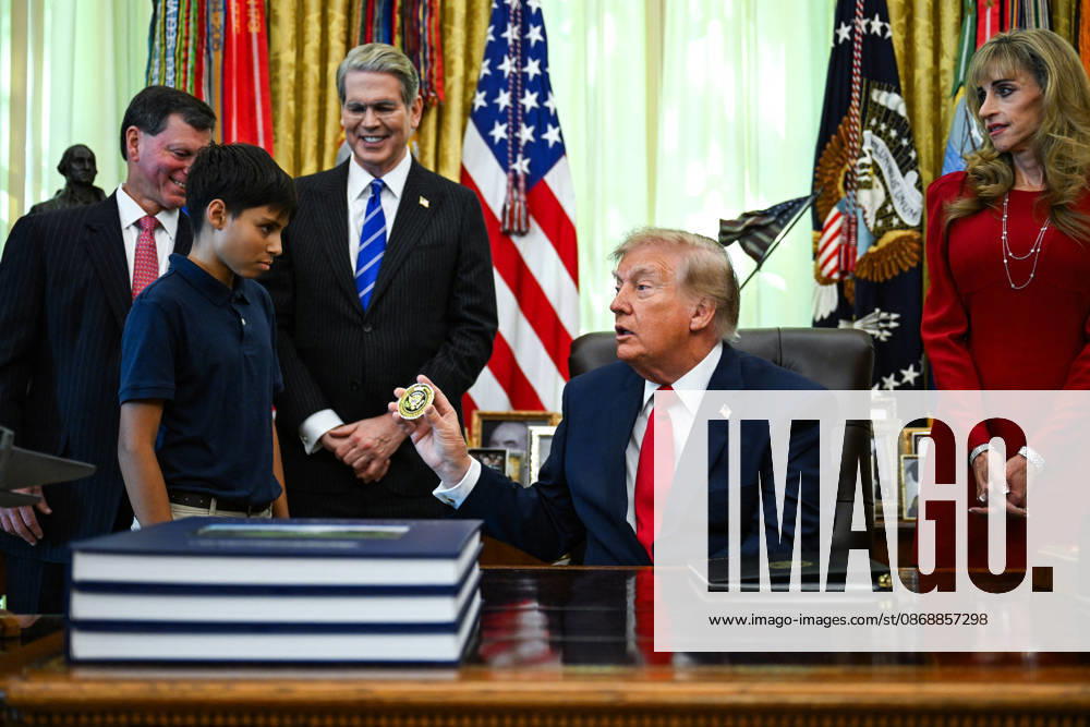Trump Makes Oval Office Announcement WASHINGTON, DC - OCT. 7: US President Donald Trump hands a challenge coin to a child during an announcement on Trump Accounts in the Oval Office on Wednesday, Oct. 7, 2026 at the White House in Washington, D.C. (Photo by Annabelle Gordon Pool For The Washington Post) Washington DC United States