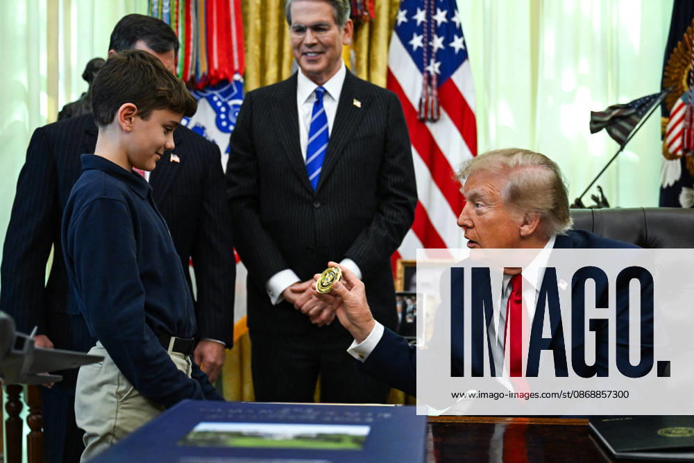 Trump Makes Oval Office Announcement WASHINGTON, DC - OCT. 7: US President Donald Trump hands a challenge coin to a child during an announcement on Trump Accounts in the Oval Office on Wednesday, Oct. 7, 2026 at the White House in Washington, D.C. (Photo by Annabelle Gordon Pool For The Washington Post) Washington DC United States