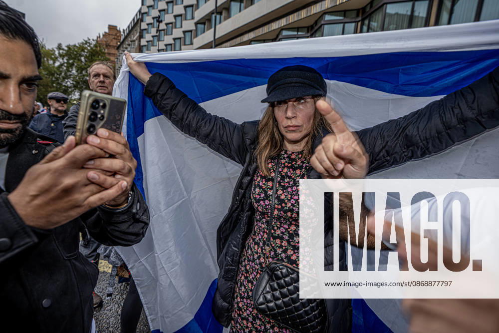 Pro-Israeil counter protestors challenge pro-Palestine demonstrators in London, UK - 7 OCT 2026. A woman seen holding a large flag during the 3rd anniversary of the October 7th attack by Hamas to protest against Israel’s war on Gaza while other protesters filming in front of her. Pro-Palestine activists from Central London Universities chose the 3rd anniversary of the October 7th attack by Hamas to protest against Israel’s war on Gaza. They clashed en route with pro-Israeli counter protestors. The demonstration was arranged by an inter-uni coalition that includes King’s College and LSE. London United Kingdom