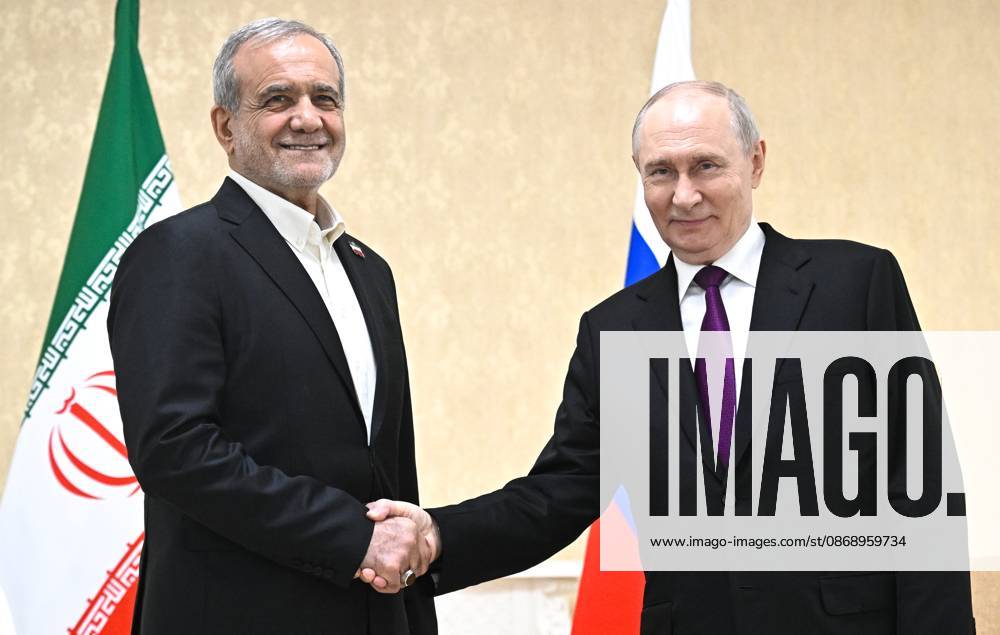 Turkmenistan Russia 9260793 08.10.2026 Iranian President Masoud Pezeshkian and Russian President Vladimir Putin shake hands as they pose for photos before a meeting in Turkmenbashi, Turkmenistan. Sergey Bobylev Sputnik Turkmenbashi Turkmenistan