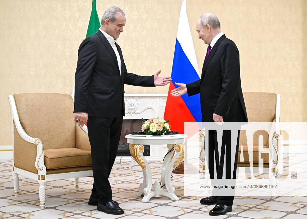 Turkmenistan Russia 9260802 08.10.2026 Iranian President Masoud Pezeshkian and Russian President Vladimir Putin shake hands before a meeting in Turkmenbashi, Turkmenistan. Sergey Bobylev Sputnik Turkmenbashi Turkmenistan