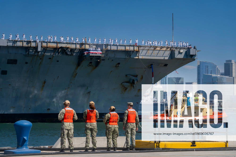 U.S. Navy sailors stand along the flight deck of the aircraft carrier USS Abraham Lincoln (CVN 72) as the ship returns to Naval Air Station North Island in Coronado, California, on October 8, 2026, following a deployment. Navy personnel stand on the pier beside the ship as a tugboat assists nearby. Coronado United States - ZUMAg374 20261008_znp_g374_008