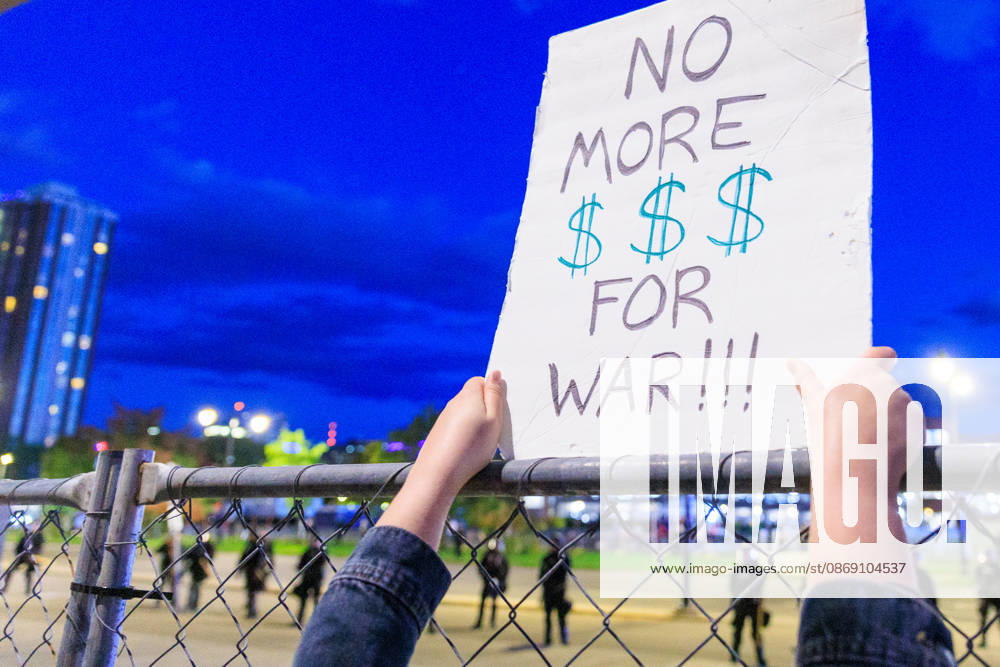 A sign held up at the security fence in front of the NY State Police in riot gear. Syracuse USA - ZUMAh195 20261009_znp_h195_007