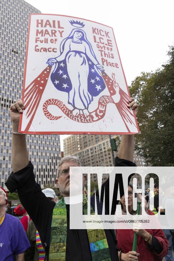 A demonstrator holds a sign that reads HAIL MARY Full of Grace KICK I.C.E. Out of This Place. Thousands of people join the Hands Off NYC coalition at a rally outside Federal Plaza in Lower Manhattan before marching through the streets for an emergency protest demanding justice the day following ICE shooting a Bronx man while his 5 year child was in the car. New York USA - ZUMAr174 20261009_znp_r174_020