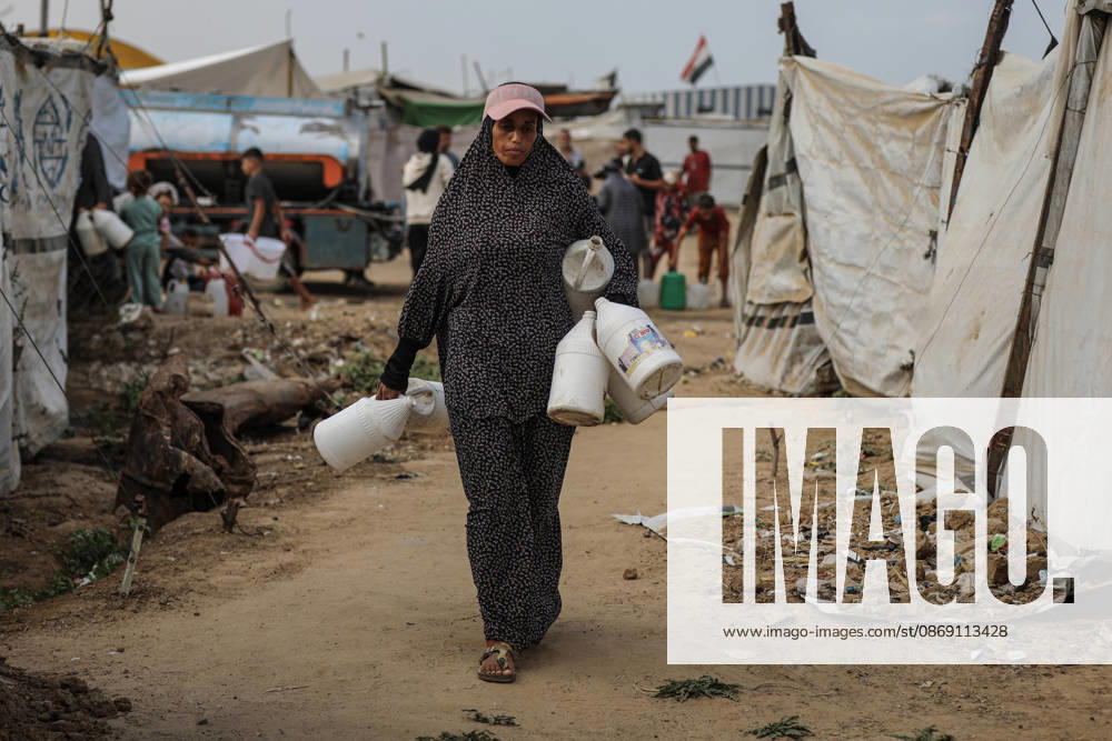 Palestinians still lack basic necessities amid Israel attacks DEIR AL BALAH, GAZA, PALESTINE - OCTOBER 10: Palestinians living in tents set up in the Bureij area carry water in containers to their makeshift shelters in Deir al Balah, Gaza, Palestine on October 10, 2026.The humanitarian crisis in the region continues to deepen, with thousands of displaced families struggling to survive without access to the most basic necessities. Adam Bilal Anadolu Deir al Balah Gaza. Editorial use only. Please get in touch for any other usage.