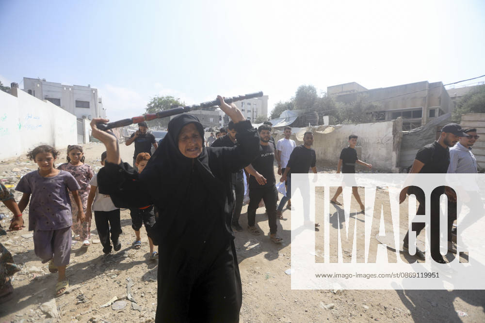 Gaza Palestine Airstrike Aftermath An elderly woman walks ahead of mourners carrying a shrouded body in Gaza City, Palestine on October 10, 2026. Four Palestinians were killed in an air strike near Panda Mall, and people carried the victims toward Al-Shifa Hospital for funeral prayers. Gaza Gaza Strip Palestinian Territories
