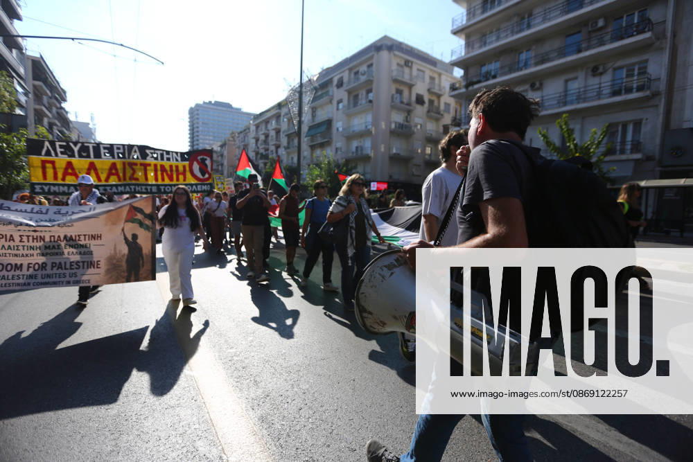 A demonstrator speaks through a megaphone as protesters march behind him carrying Palestinian flags and banners. Athens GREECE - ZUMAx103 20261010_zip_x103_017