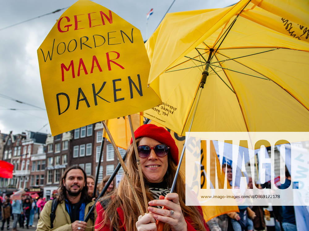 A protester is holding a yellow placard that says No words, but roofs during the demonstration. People gathered against the worsening housing crisis. Under the motto Houses for people, not for profit, they demand fundamental changes in Dutch public housing. Amsterdam Netherlands - ZUMAs197 20261010_aaa_s197_550
