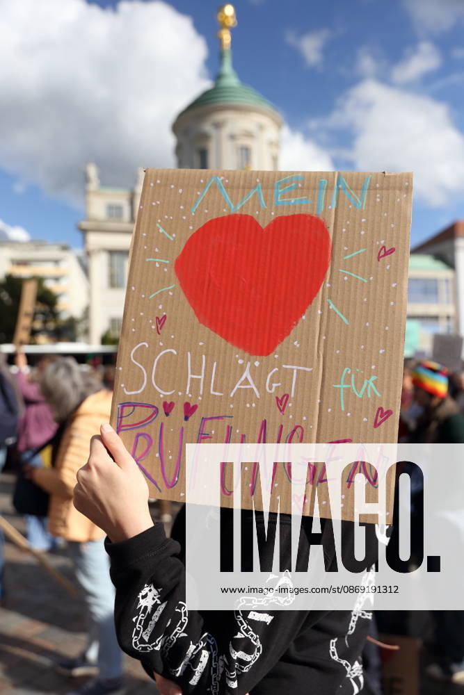 Eine Demonstrantin steht mit Schild Mein Herz schlägt für Prüfungen auf dem Alten Markt während einer Demonstration für die Überprüfung rechtsextremer Parteien durch das Bundesverfassungsgericht, Potsdam, 10. Oktober 2026. Prüf-Demo in Potsdam