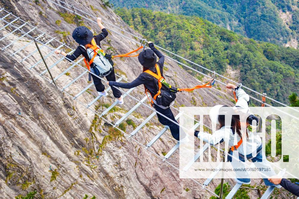 China Sky Ladder Challenger Tourists climb up a 250-meter-long soft ladder between two mountains in Mingtangshan Scenic Area in Yuexi county in central China s Anhui province, Sunday, Oct. 11, 2026. The rope ladder has 620 steps and a vertical distance of 365 meters. It opened to tourists in June this year, and quickly became a tourist attraction., Credit:stringer Utuku Feature China Avalon CHINA, ANHUI, YUEXI