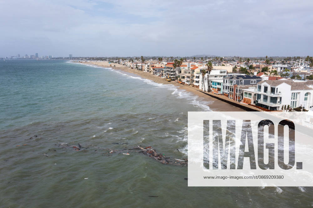 The Long Beach Peninsula is facing severe, structural devastation as Tropical Storm Rachel batters the Southern California coast. Driven by a developing El Nino pattern, this is the fourth major storm system to slam the shoreline in six weeks. Waves and unusually high tides have shattered a 30-foot section of the protective wooden bulkhead, completely shredding the historic boardwalk and allowing seawater to surge directly onto interior streets. Flooding has swamped coastal neighborhoods, forcing mandatory evacuations along oceanfront blocks like Seaside Walk. Emergency crews are working to stack thousands of sandbags and reinforce coastal defenses, but city inspectors have already been forced - ZUMAr19_ 20261011_new_r19_139
