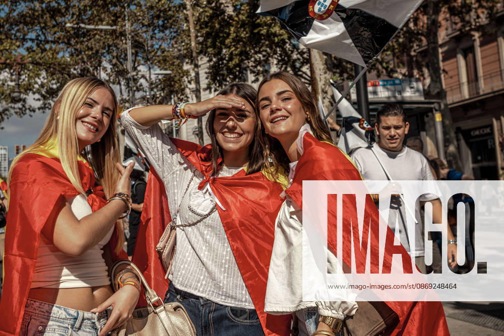 Three women wrapped in Spanish flags pose beneath a flag of Ceuta during a demonstration marking Spainâ€⠢s National Day. Barcelona Spain - ZUMAo105 20261012_fap_o105_002