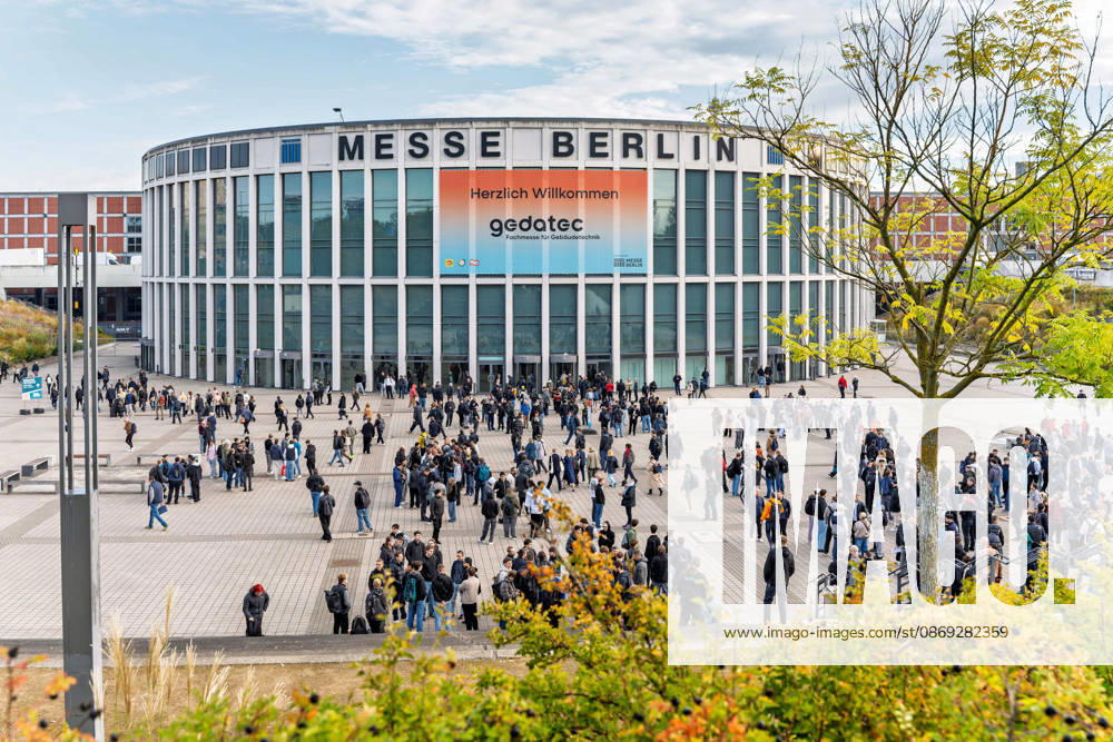 Berlin, 13.10.2026: Hunderte Fachbesucher warten am Morgen auf dem Vorplatz vor dem Eingang Süd der Messe Berlin auf den Einlass zur gedatec, während ein Baum im Vordergrund bereits herbstlich gefärbt ist. Die gedatec, Fachmesse für Gebäudetechnik, findet vom 13. bis 15. Oktober 2026 erstmals auf dem Berliner Messegelände statt und geht aus der Elektrotechnik-Fachmesse belektro hervor. Unter einer Dachmarke bündelt sie Elektrotechnik, Sanitär-, Heizungs- und Klimatechnik sowie das Dachdeckerhandwerk und richtet sich an Fachbesucher aus Handwerk, Planung und Industrie. Warten auf den Einlass zur gedatec