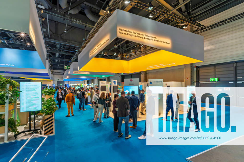 Berlin, 13.10.2026: Besucher am Stand des Ministeriums für Heimat, Kommunales, Bau und Digitalisierung des Landes Nordrhein-Westfalen auf der Smart Country Convention; links ist der Stand von Smart City Berlin zu sehen, im Hintergrund der des Landkreistags. Zahlreiche Bundesländer, Städte und kommunale Spitzenverbände präsentieren auf der Messe ihre Projekte zur digitalen Verwaltung. Die Smart Country Convention (SCCON) ist die Kongressmesse für die Digitalisierung des öffentlichen Sektors und wird vom Digitalverband Bitkom gemeinsam mit der Messe Berlin veranstaltet. Vom 13. bis 15. Oktober 2026 treffen sich auf dem Berliner Messegelände Vertreter aus Bund, Ländern und Kommunen mit Unternehmen der Digitalwirtschaft, um über digit