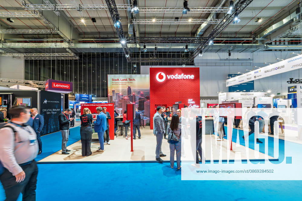 Berlin, 13.10.2026: Besucher am roten Messestand von Vodafone unter dem Motto Stadt. Land. Tech. auf der Smart Country Convention; der Telekommunikationskonzern wirbt dort für digitale Infrastruktur für Kommunen und für einsatzkritische Kommunikation (Mission Critical Communication), daneben die Stände von Lenovo und des Walletforums. Die Smart Country Convention (SCCON) ist die Kongressmesse für die Digitalisierung des öffentlichen Sektors und wird vom Digitalverband Bitkom gemeinsam mit der Messe Berlin veranstaltet. Vom 13. bis 15. Oktober 2026 treffen sich auf dem Berliner Messegelände Vertreter aus Bund, Ländern und Kommunen mit Unternehmen der Digitalwirtschaft, um über digitale Verwaltung, Smart City und digitale Souve