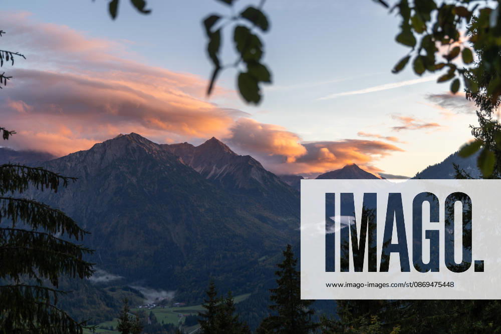 Herbstabend im Allgäu Die Wolken am Himmel leuchten im Licht der Abendsonne über den Gipfeln der Allgäuer Alpen., Bad Hindelang Bayern Deutschland