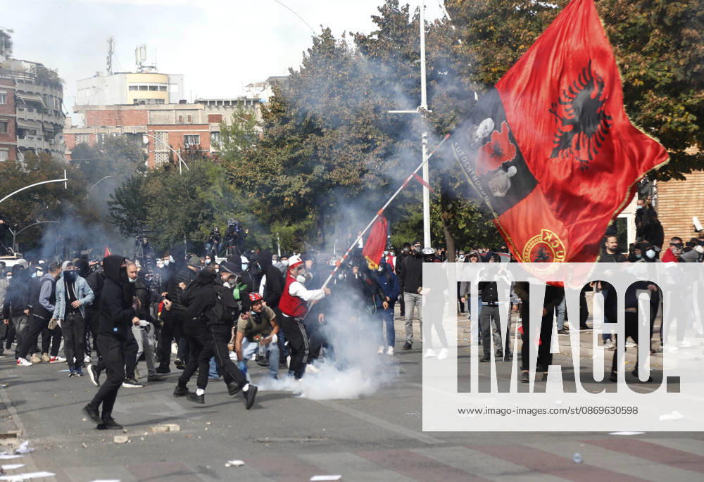 Protesters Clash with Police During a Demonstration in Tirana, Albania. Protesters hold an Albanian flag as they throw stones to riot police during an anti-government demonstration in central Tirana on October 15, 2026, as protests continued for a third consecutive day over university conditions and demands for the resignation of Albanian Prime Minister Edi Rama. The latest rally follows two nights of violence in the capital, during which protesters and riot police clashed, police used water cannons and tear gas, and demonstrators damaged government offices and shops and set fire to several buildings. Light Studio Agency Malton Dibra Tirana Albania