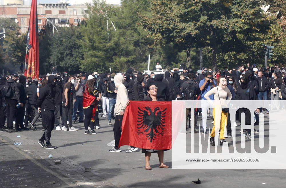 Protesters Clash with Police During a Demonstration in Tirana, Albania. Protesters hold an Albanian flag as they throw stones to riot police during an anti-government demonstration in central Tirana on October 15, 2026, as protests continued for a third consecutive day over university conditions and demands for the resignation of Albanian Prime Minister Edi Rama. The latest rally follows two nights of violence in the capital, during which protesters and riot police clashed, police used water cannons and tear gas, and demonstrators damaged government offices and shops and set fire to several buildings. Light Studio Agency Malton Dibra Tirana Albania