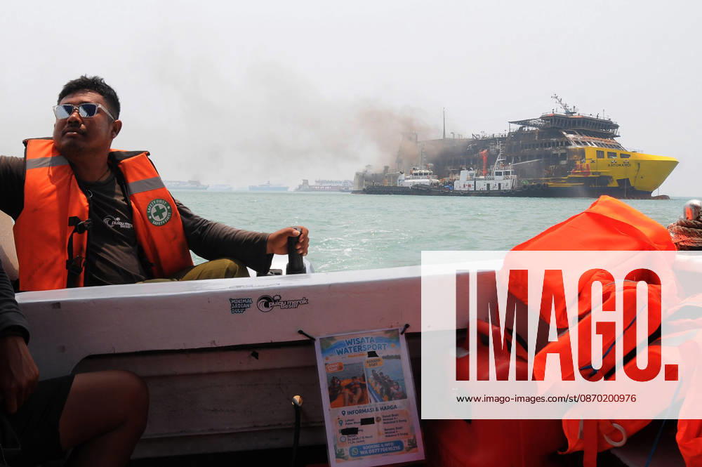Efforts are underway to extinguish a fire that broke out on a passenger ferry in Indonesia s Cilegon PELABUHAN MERAK, CILEGON, INDONESIA - OCTOBER 21: Fireboats take turns spraying water onto the passenger ferry KMP Batumandi to cool down the vessel after it caught fire while preparing to dock off Merak Port in Cilegon, Banten, Indonesia on Wednesday, October 21, 2026. The vessel caught fire on Tuesday, October 20, and rescue operations remain underway as the ship continues to emit smoke. Water is continuously sprayed to cool the vehicle deck containing numerous cars, motorcycles, buses, and trucks, while authorities confirm no fatalities have been reported. Dasril Roszandi Anadolu Pelabuhan Merak Indonesia. Editorial use only. Please get