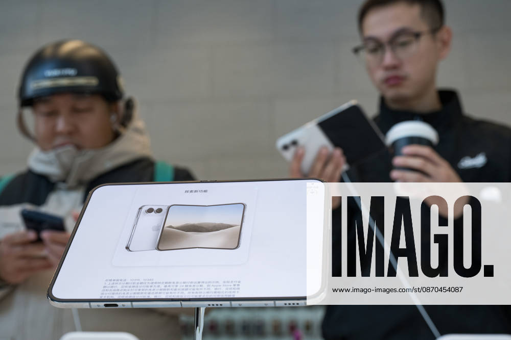 Consumers experience the new iPhone Duo foldable smartphone at an Apple Store in Beijing, China on October 23, 2026. Apple has launched its first foldable phone model for sale starting today.