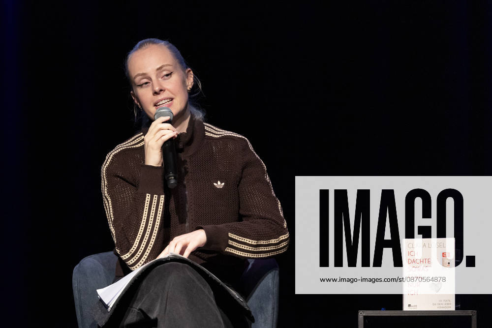 Poetry Artist, Autorin Clara LOESEL (LÖSEL) lesend, bei ihrer Lesung, Previewshow zu ihrem neuen Buch ,Ich dachte, sowas fuehl nur ich, sitzend, mit Mikrofon, Einzelbild, Einzelfoto, im Theater am Tanzbrunnen, Koeln, am 23.10.2026.
