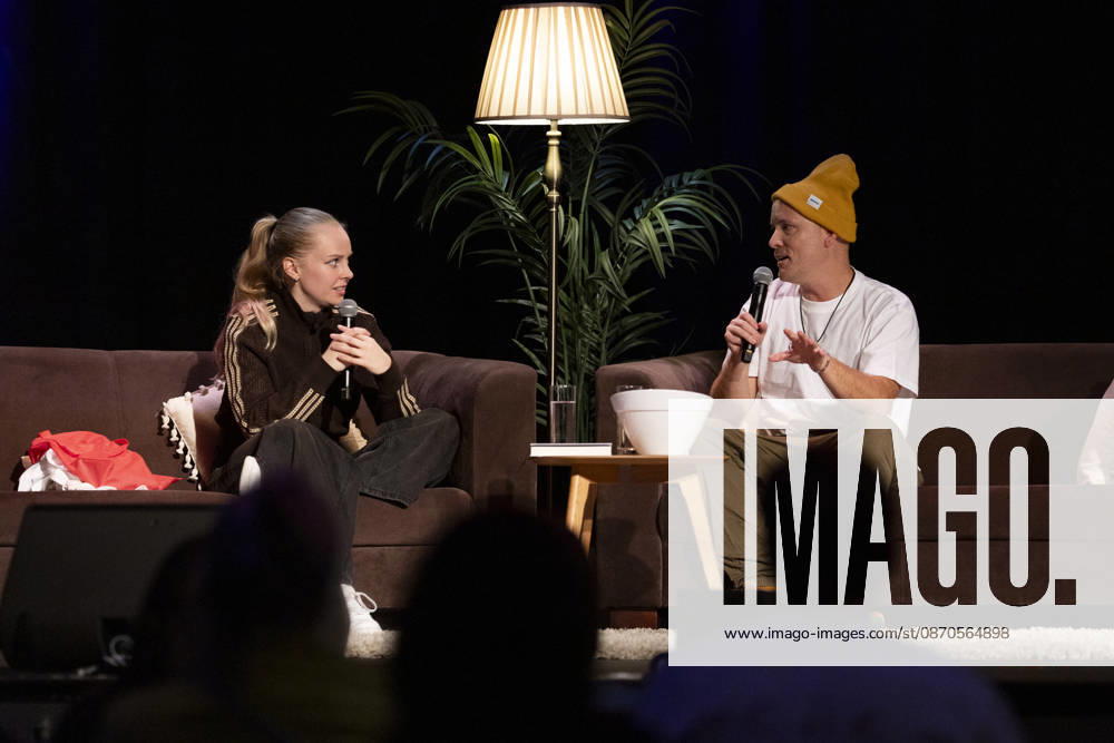 Poetry Artist, Autorin Clara LOESEL (LÖSEL) (li.) im Gespraech mit Autor und Podcaster Lars AMEND (re.), bei ihrer Lesung, Previewshow zu ihrem neuen Buch ,Ich dachte, sowas fuehl nur ich, auf Sofas sitzend, mit Mikrofonen, im Theater am Tanzbrunnen, Koeln, am 23.10.2026.