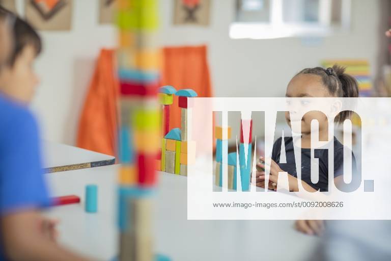 Girl looking at tower of building blocks in kindergarten model released Symbolfoto property released ZEF15437