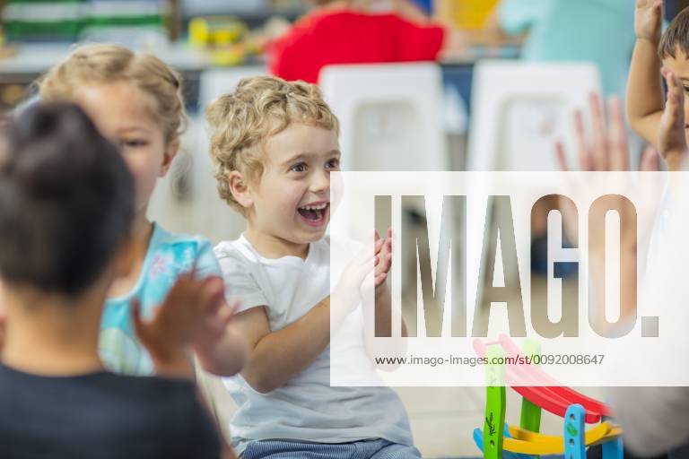 Happy children and pre-school teacher clapping hands in kindergarten model released Symbolfoto property released ZEF15442