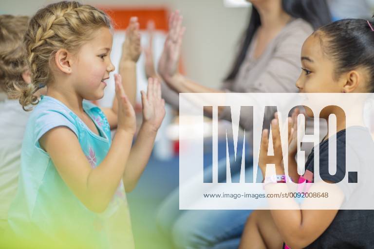Happy children and pre-school teacher clapping hands in kindergarten model released Symbolfoto property released ZEF15443