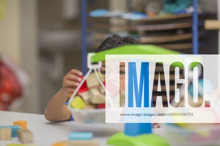 Boy playing with toy scales in kindergarten model released Symbolfoto property released ZEF15482