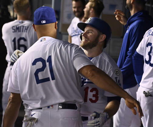 Los Angeles Dodgers Max Muncy (13) celebrates with teammate Albert Pujols in the dugout after hitting a solo home run off Arizona Diamondbacks starting pitcher Merrill Kelly in the fifth inning to give the Dodgers a 4-2 lead at Dodger Stadium in Los Angeles on Wednesday, September 15, 2021. Puljos, a former recipient of the Roberto Clemente philanthropic and humanitarian award is wearing number 21 in honor of Roberto Clemente Day.  LAP2021091502 JIMxRUYMEN