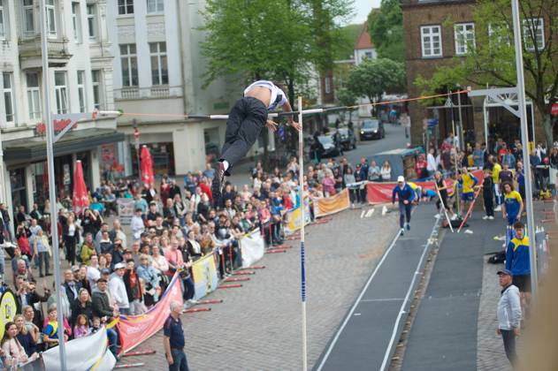 Flensburg, Schleswig-Holstein 1. Flensburger Marktplatzspringen, im Rahmen des Active City Festivals. Hier: Stabhochspringer beim Spung, er überwindet die Latte. Aufnahme vom 04.05.2024, Flensburg, Südermarkt