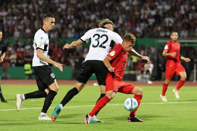 im Zweikampf, Aktion, mit Joshua Kimmich 6 (FC Bayern Muenchen), Philipp Strompf 32 (SSV Ulm 1846), SSV Ulm 1846 vs. FC Bayern Muenchen, Fussball, DFB-Pokal, 1. Runde, 16.08.2024 DFB regulations prohibit any use of photographs as image sequences and or quasi-video Ulm Baden-Wuerttemberg Deutschland