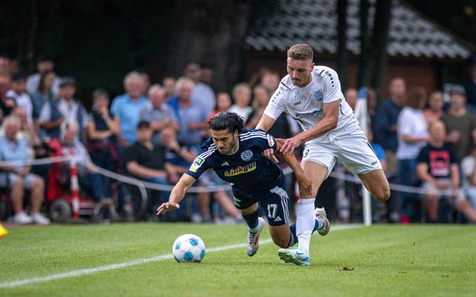 Fussball, Saison 2024 2025, Niederrheinpokal 20.08.2023, 01. Runde, Herren, BW Dingden (weiss) vs. MSV Duisburg (schwarz) v.l.: Mert Goeckan (MSV Duisburg), Lasse Hoffmann (BW Dingden), Hamminkeln Sportanlage BW Dingden Nordrhein-Westfalen Deutschland
