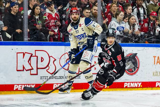 Eishockey Penny-DEL 22.Spieltag Kölner Haie - Schwenninger Wild Wings am 01.12.2024 in der Lanxess Arena in Köln Thomas Larkin ( Schwenningen ), links - Moritz Müller ( Köln ), rechts Gemäß den Vorgaben der DEL Deutsche Eishockey Liga ist die Publikation und Weiterverwertung der Aufnahmen in elektronischen Medien und Endgeräten aller Art während des laufenden Spiels nicht zulässig.