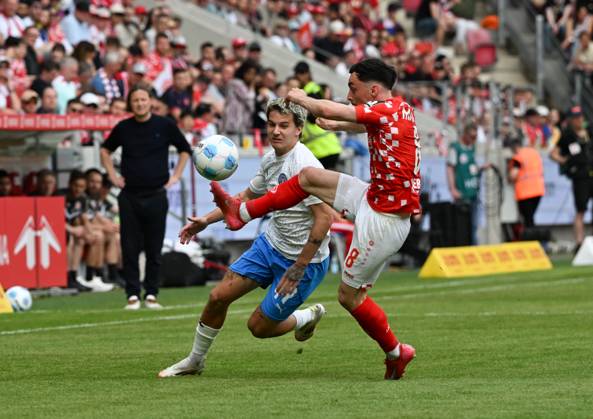 05.04.2025, xsltx, Fussball 1.Bundesliga, FSV Mainz 05 - Holstein Kiel v.l. John Tolkin (Holstein Kiel), Paul Nebel (1. FSV Mainz 05) (DFL DFB REGULATIONS PROHIBIT ANY USE OF PHOTOGRAPHS as IMAGE SEQUENCES and or QUASI-VIDEO)