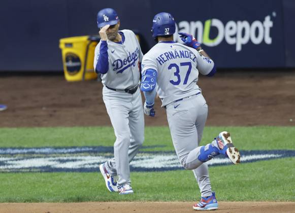 Los Angeles Dodgers Teoscar Hernandez (37) is congratulated by third base coach Dino Ebel after hitting a solo home run in the second inning against the Milwaukee Brewers during game two of the MLB, Baseball Herren, USA National League Championship Series at American Family Field in Milwaukee, Wisconsin, on Tuesday, October 14, 2025. MIL20251014708 TANNENxMAURY